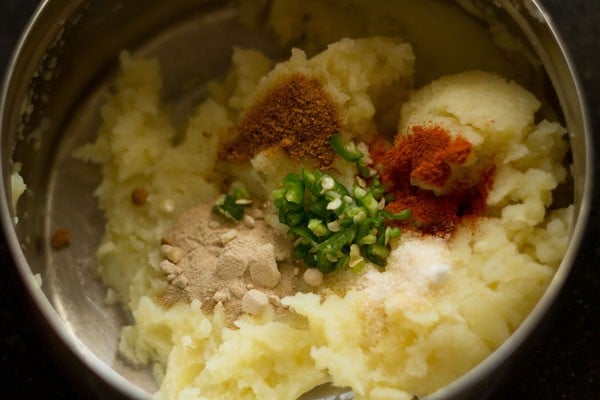 add spices and chilies to mashed aloo.