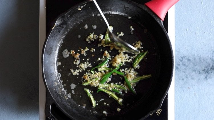 silver spoon mixing sautéed aromatics