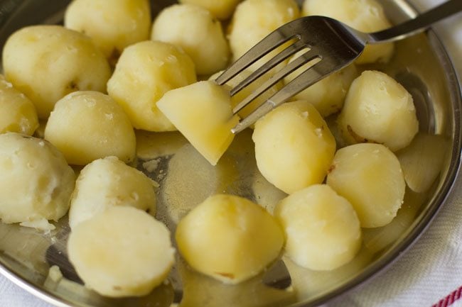 pricking peeled potatoes.