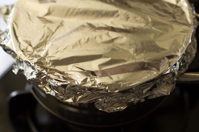 pan with potato curry sealed with an aluminum foil. 