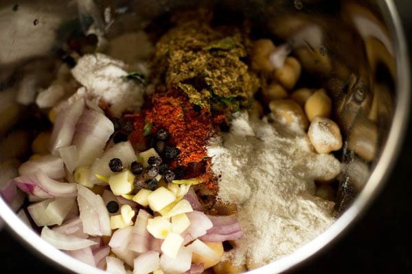 spices and herbs added to soaked chickpeas in the grinder.