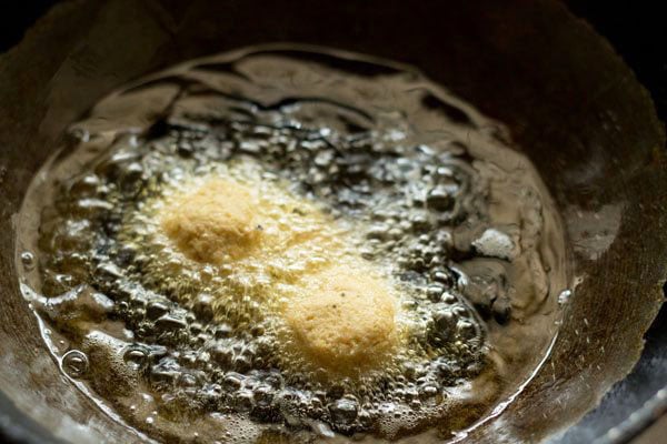 medium sized balls of falafel mixture placed in hot oil.