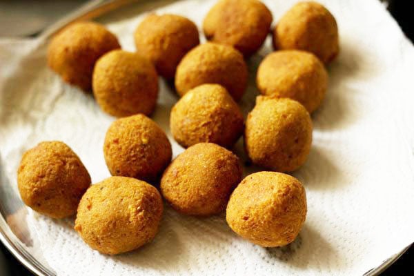 many fried falafel balls placed on kitchen paper towel.