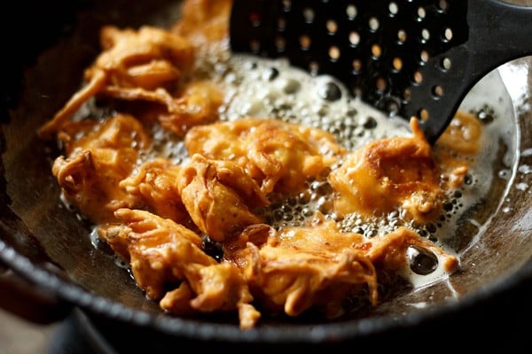 frying onion pakoda in hot oil till crisp and golden. 
