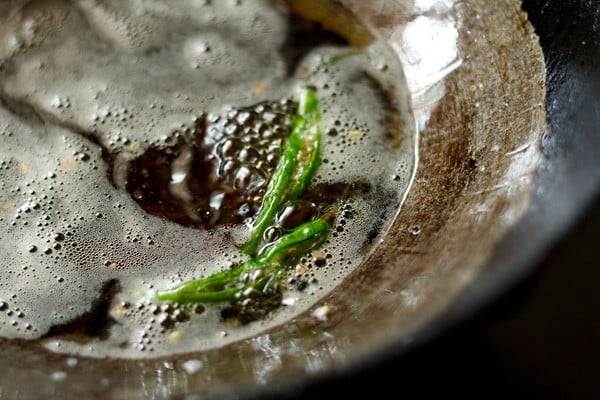frying green chilies for serving with pakoda. 