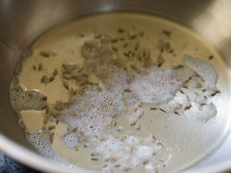 crackling cumin seeds in hot oil for paneer bhurji recipe. 