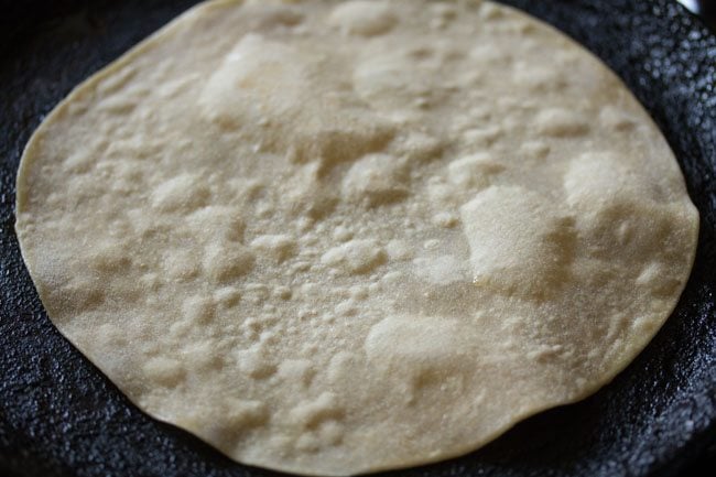 roti is flipped again, exposing a dry side.