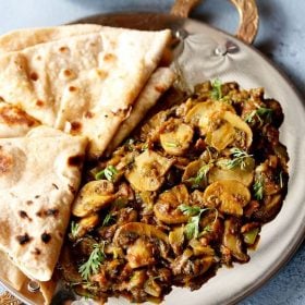 tawa mushroom serve don a plate with a side of chapati.
