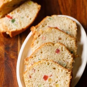 tutti frutti cake slices served on a white platter.